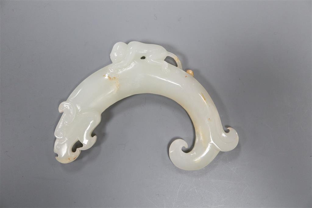 A Chinese archaistic white and russet jade plaque, 9.5cm, carved with a monkey